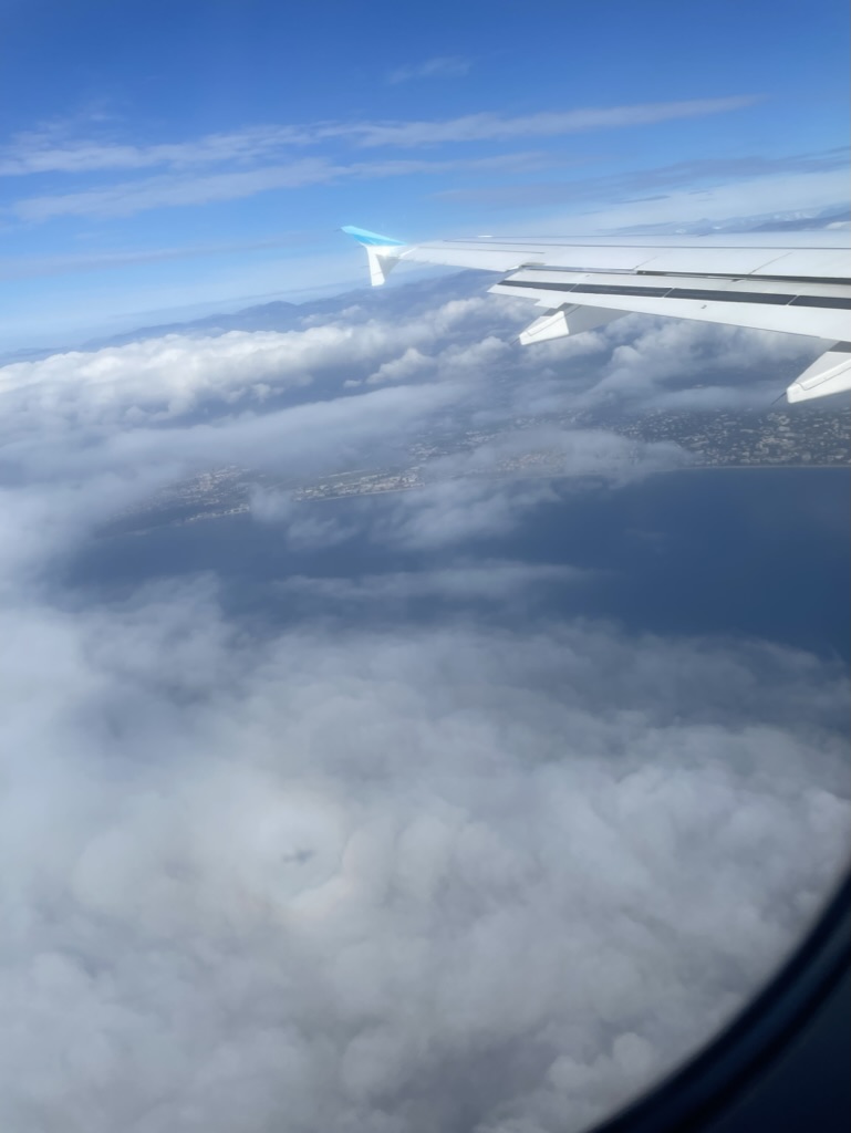 airplane wing clouds sky travel insurance solo travel wandersister