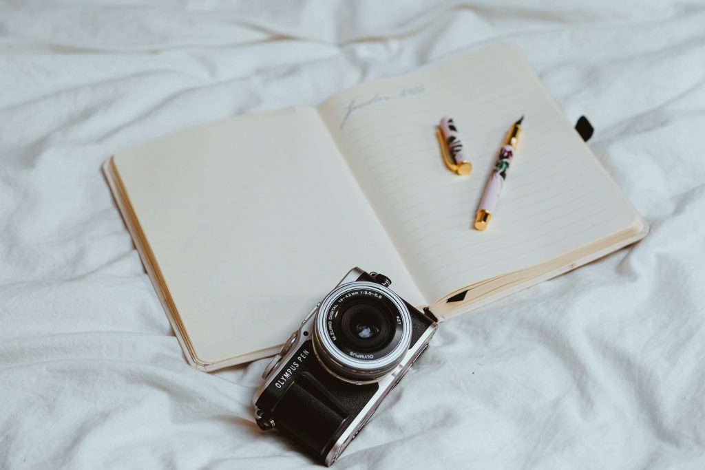 how to plan a solo trip open notebook fountain pen camera on sheets