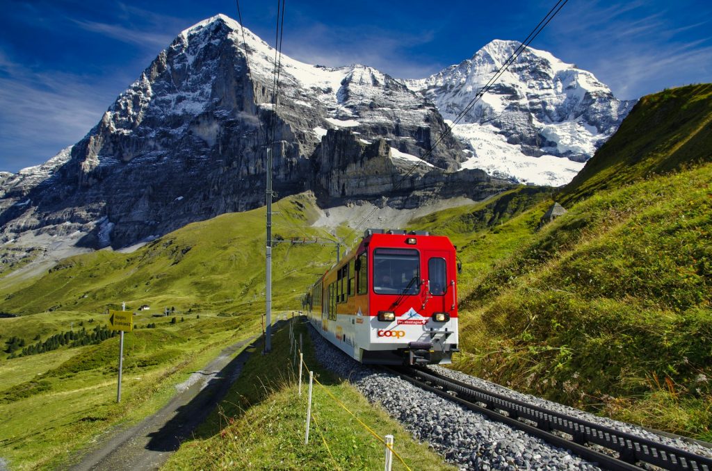 switzerland solo travel red train passing scenic majestic swiss alps mountains