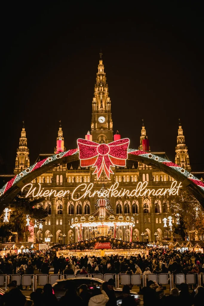 A festive Christmas market glowing before a grand Vienna palace, illustrating Vienna Christmas markets for women over 50.