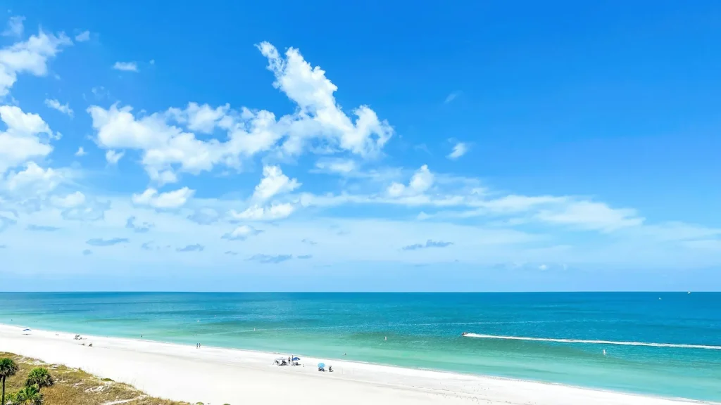 Turquoise water and white sand on Florida's Gulf Coast under a bright blue sky, a solo travel Florida beach escape.