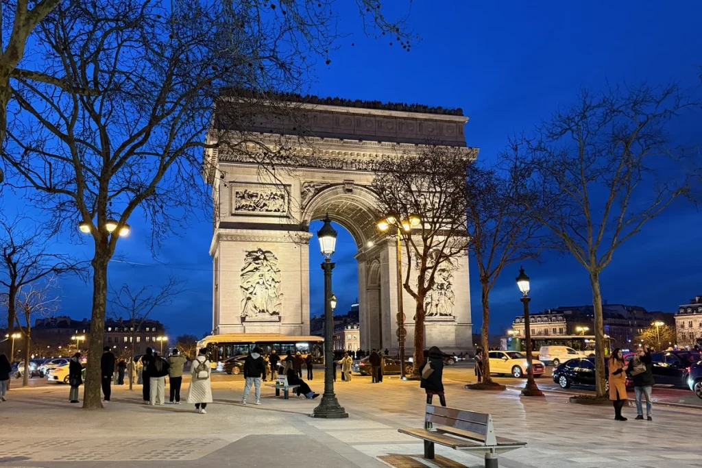 The Arc de Triomphe lit at blue hour at the top of the Champs-Élysées in Paris, a 3 days in Paris itinerary for women over 50