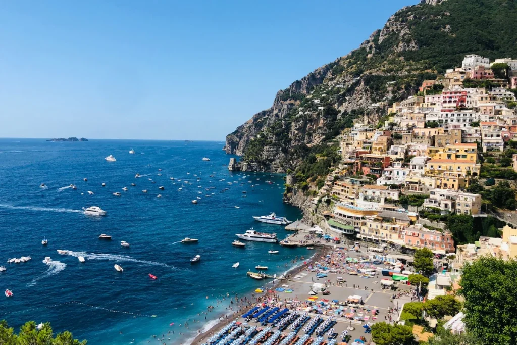 The colorful cliffside houses of Positano above the deep blue sea on the Amalfi Coast, one of the best day trips from Rome for women over 50