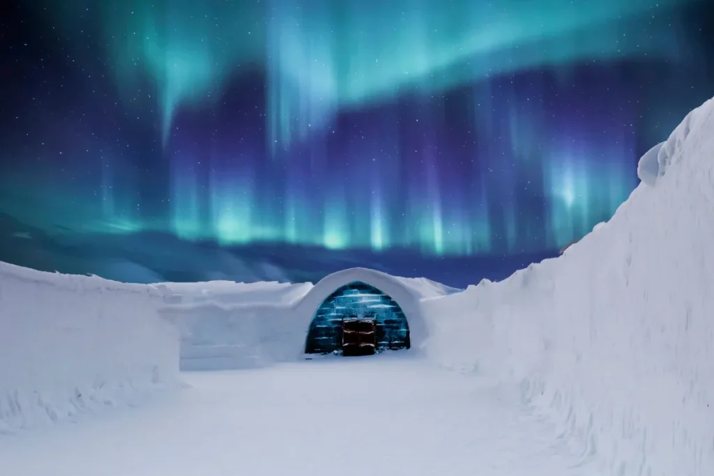Finland Northern Lights: a green and teal aurora blazing over a snow-covered ice igloo in Lapland on a starry winter night.