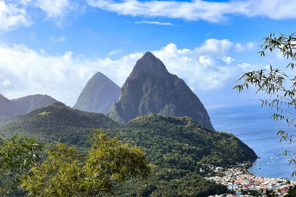 Solo travel St Lucia: the twin Pitons rising above the town of Soufrière and the Caribbean sea, a guide for women over 50.